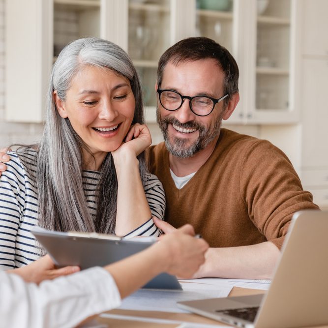 A smiling couple reading a business proposal.