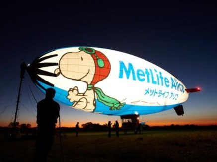 A large blimp featuring a cartoon character and advertising MetLife.