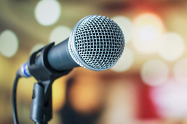 Close-up of a microphone on a stand with a blurred background.