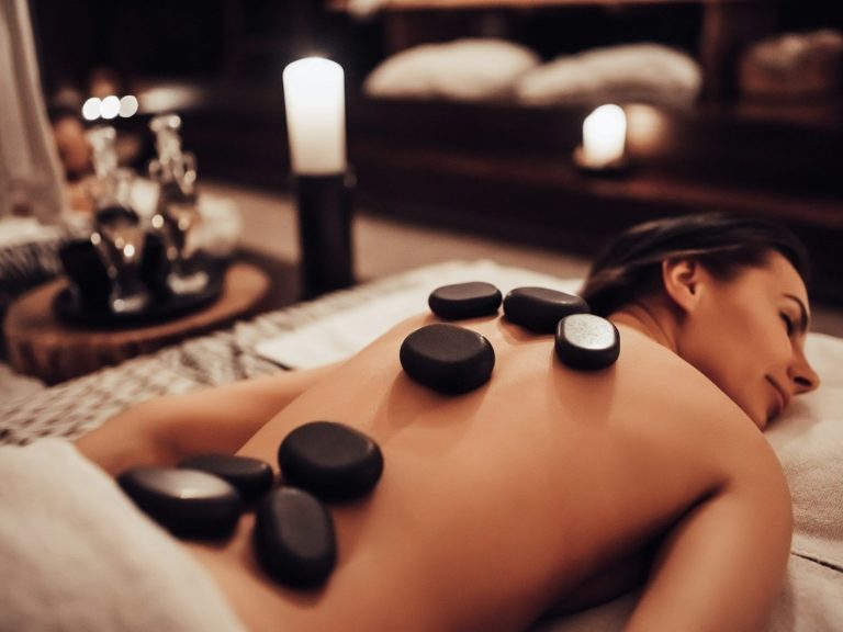 Massages at Birch and Ink Retreat A person receiving a hot stone massage with several stones on their back.