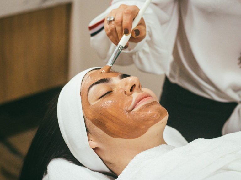 Facials at Birch and Ink Retreat A person receiving a facial treatment with a brown mask applied to their face.