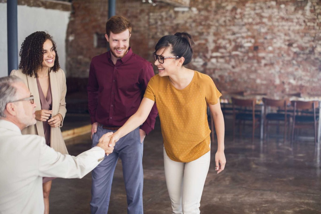 A group of four people interacting warmly in a casual setting.