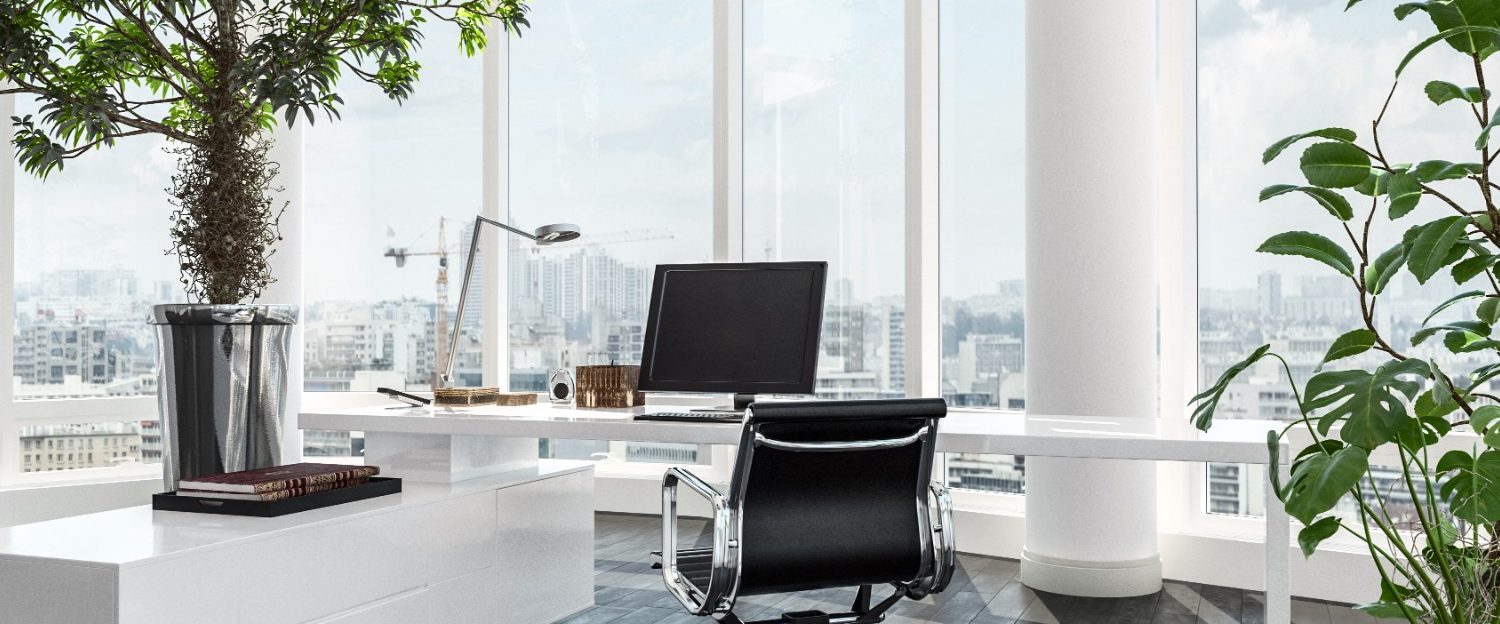 Modern office with large windows, greenery, and a sleek ergonomic chair.